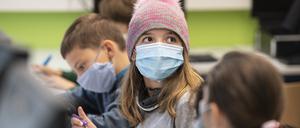 Mit Mundschutzmasken sitzen Schüler der fünften Klasse eines Gymnasiums  im Unterricht.