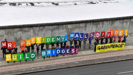 Aktivisten demonstrieren vor der Berliner Mauer gegen den neuen US-Präsidenten.