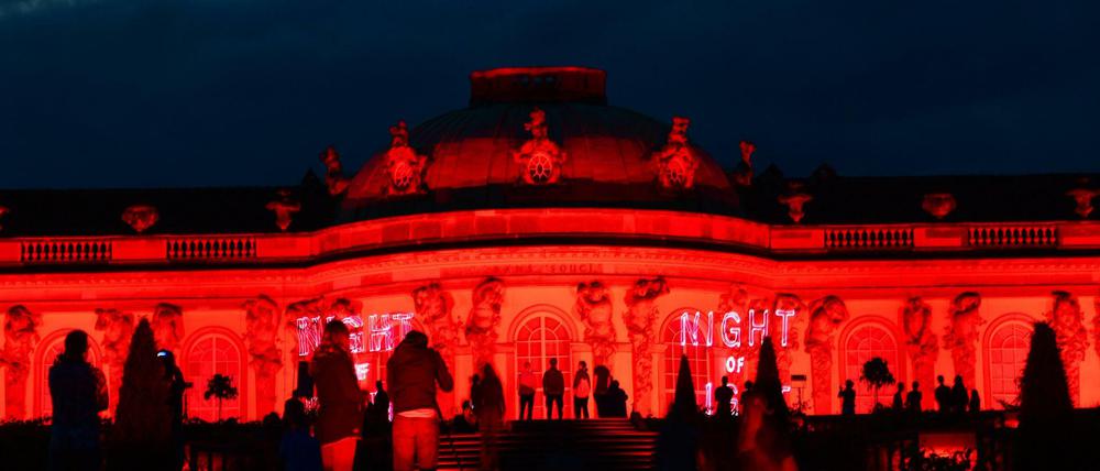 Das Schloss Sanssouci in rotem Licht, stellvertretend für die bedrohte Konzertbranche.
