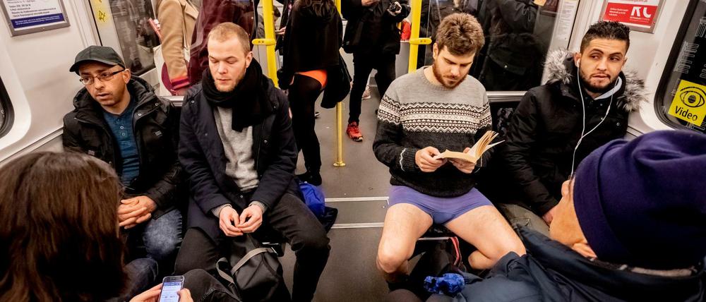 Ein Mann in Unterhose sitzt bei der Aktion "No Pants Subway Ride" in einer U-Bahn. 