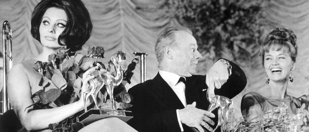 Sophia Loren und Liselotte Pulver, links und rechts von Heinz Rühmann, bei der Bambi Verleihung im Jahr 1964. 