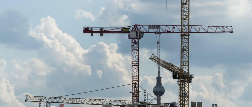 Baukräne über einer Baustelle für Luxuswohnungsneubauten am nördlichen Rad der Berliner Mauerparks Wohnungsbau in Berlin.