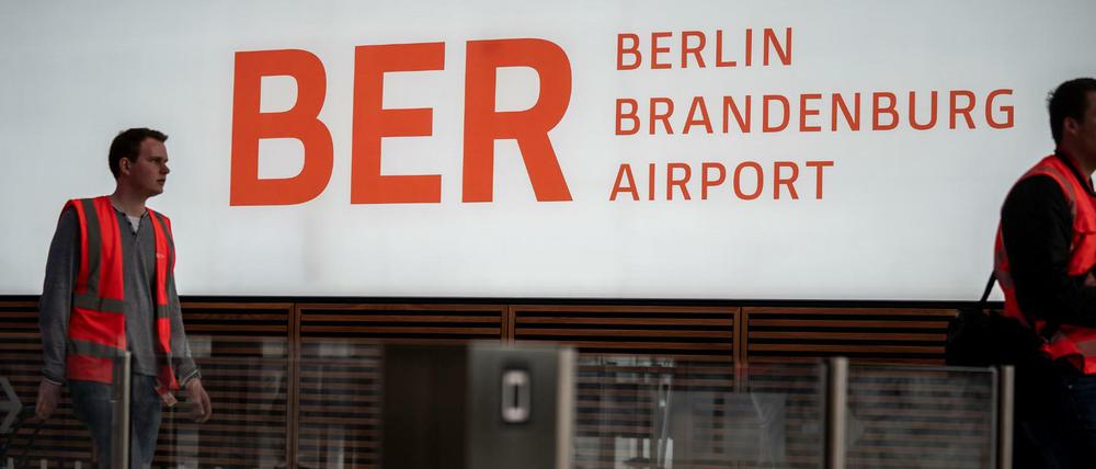 Techniker und Arbeiter sind in der Abflughalle des neuen Flughafens Berlin-Brandenburg Willy-Brandt unterwegs.
