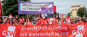 Teilnehmer:innen der Demonstration der Gewerkschaft Erziehung und Wissenschaft (GEW) tragen ein Plakat mit der Aufschrift «unterrichten statt untergehen!». 