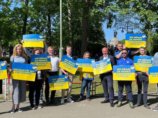 Stefan Evers und Kai Wegner zeigen zusammen mit anderen CDU-Politiker und der russischen Aktivistin und Journalistin Olga Romanowa Solidaritätsbekundungen mit der Ukraine. 