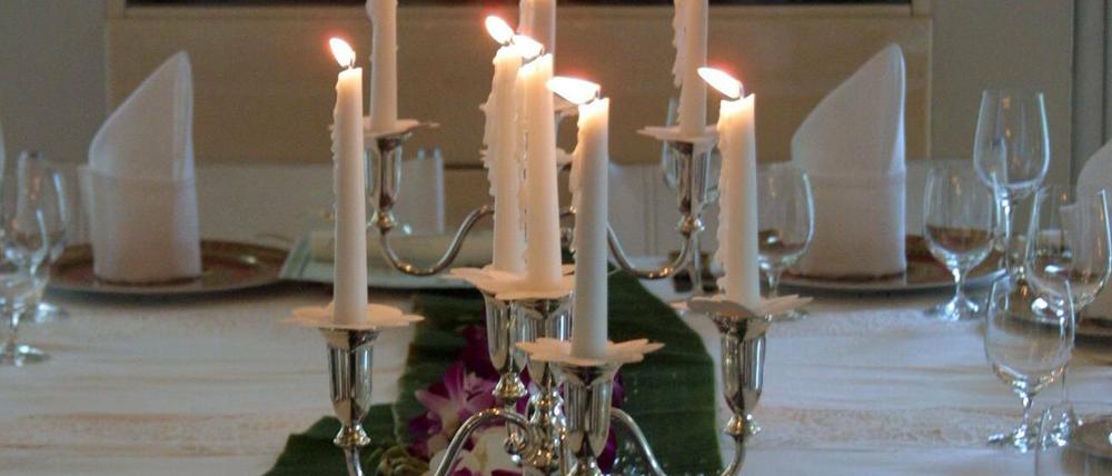 Symbolbild. Kerzenleuchter auf einem gedeckten Tisch. 