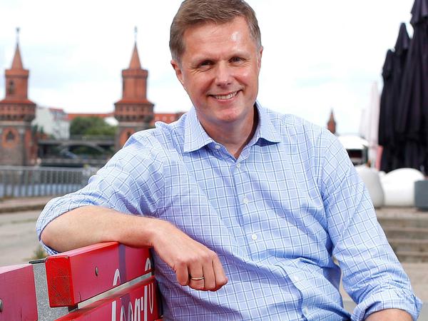 Bjørn Jensen, Deutschland-Chef von Coca-Cola, sitzt auf einer Bank auf der Terrasse der Firmenzentrale am Spreeufer in Berlin-Friedrichshain.
