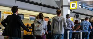 Reisende an einem Check-in-Schalter auf dem Flughafen Tegel.