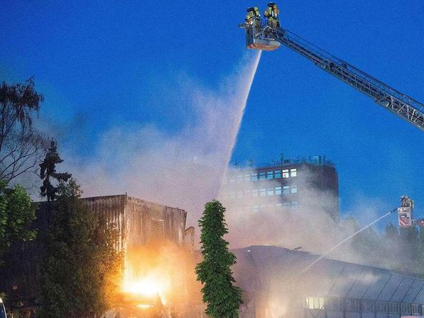 Bild aus der Nacht in Neukölln: Feuerwehrleute löschen den 650 Quadratmeter großen Brand in der Lagerhalle in der Schmalenbachstraße.