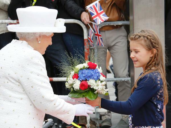 Die britische Königin Elizabeth II. nimmt einen Blumenstrauß von der 10-jährige Louisa entgegen, bevor sie die TU verlässt.