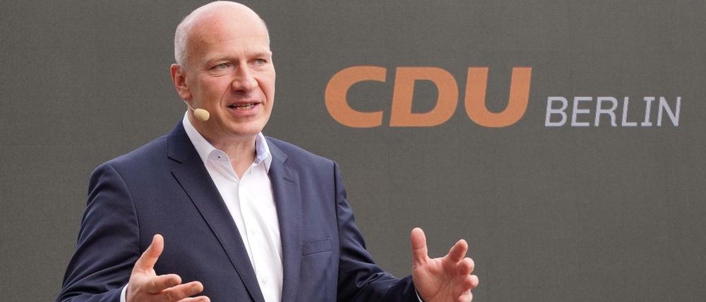 Kai Wegner, Landesvorsitzender der Berliner CDU vor dem neuen Logo - jetzt in orange auf schwarzem Grund. 