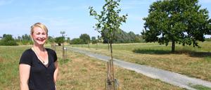 Cordelia Koch , Vorstandsmitglied von Bündnis 90/Die Grünen, zeigt frisch gepflanzte und pflegebedürftige Obstbäume.