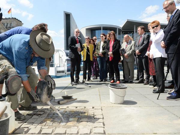 Seit 2015 erinnern zehn von Gunter Demnig (links) verlegte Stolpersteine vor dem Bundestag an die jüdischen Mieter, die einst am Schiffbauerdamm 29 lebten.