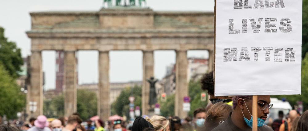 Teilnehmer der ´Black Lives Matter»-Demonstration ziehen mit einem Schild durch Berlin.