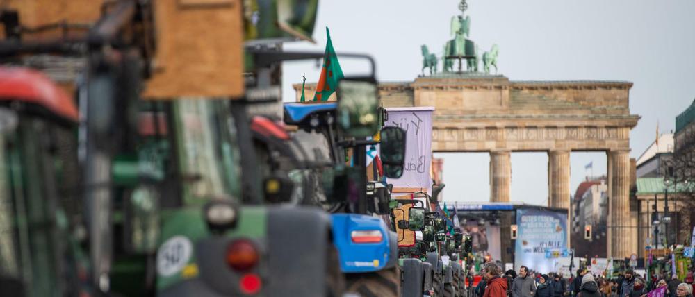 Bauern stehen mit ihren Traktoren auf der Straße des 17. Juni vor dem Brandenburger Tor.