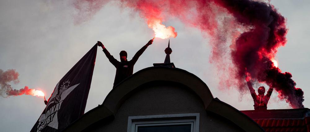 Demonstranten zünden während einer Demonstration gegen die Räumung der Szene-Kneipe Syndikat auf einem Dach Rauchpatronen.