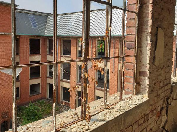 Blick aus einem zerstörten Fenster auf die verlassenen Tuchfabriken von Noack und Bergami: Das Areal ist bei Fans von "Lost Places" beliebt.