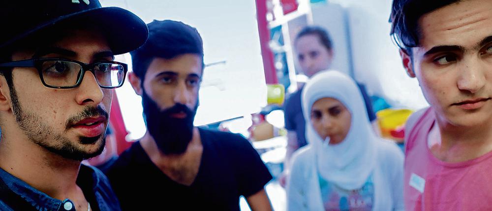 Neuberliner. Syrische Flüchtlinge, die vom Verein „Moabit hilft“ betreut werden, verfolgen die Nachrichten aus ihrer alten Heimat auf einem Smartphone. 
