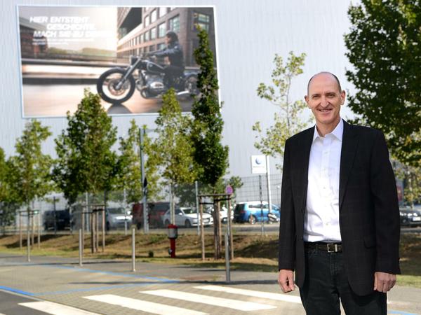 Helmut Schramm beim Rundgang durch das BMW Motorradwerk. An einer Hallenaußenwand wirbt ein riesiges Plakat für die neue "Big Boxer" auf Basis des Conceptbikes R 18. Es soll ab Ende 2020 in Berlin produziert werden. Damit will BMW Konkurrenten Harley-Davidson direkt im Markt angreifen.
