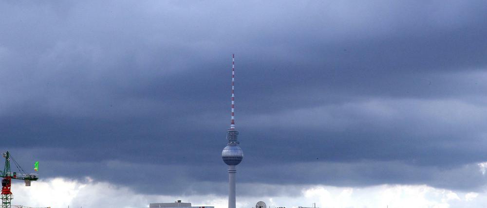 Dunkle Regenwolken hängen über dem Fernsehturm am Alexanderplatz in Berlin.