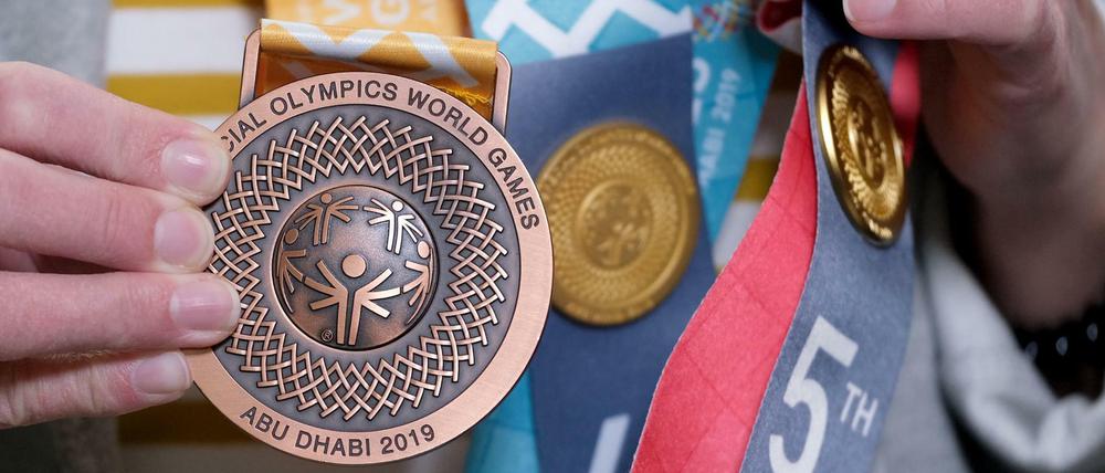 Eine Teilnehmerin der Special Olympics in Abu Dhabi zeigt ihre Medaille. 2023 sollen die Spiele in Berlin stattfinden. 