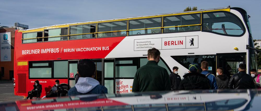 Menschen stehen auf dem Gelände des Dong Xuan Centers vor dem ersten Berliner Impfbus, um sich gegen Corona impfen zu lassen.