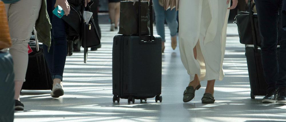 Reisende gehen mit ihrem Gepäck durch ein Terminal des Flughafen Tegel (Symbolbild).