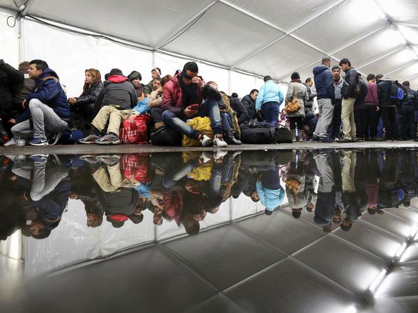 Bei kühlen Temperaturen und Regen warten Flüchtlinge am 15.10.2015 vor einer riesigen Wasserpfütze in einem Zelt auf dem Gelände des Landesamtes für Gesundheit und Soziales (LaGeSo) in Berlin auf die Registrierung und die Zuweisung eines Schlafplatzes. Im Bundestag wird am 15.10.2015 über das Asylbeschleunigungsgesetz abgestimmt. 