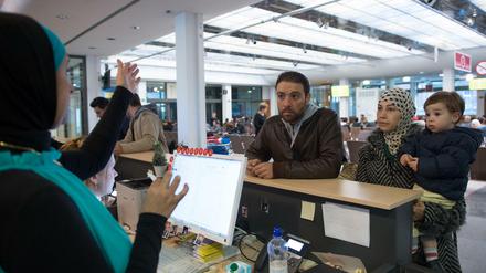 Eine Sprachmittlerin hilft in der Registrierungsstelle für Flüchtlinge in Berlin einer Familie aus Syrien bei der Orientierung im Gebäude.
