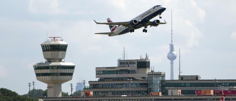 Blick auf das Hauptterminal des Flughafens Tegel, davor Flugzeuge, im Hintergrund der Fernsehturm.