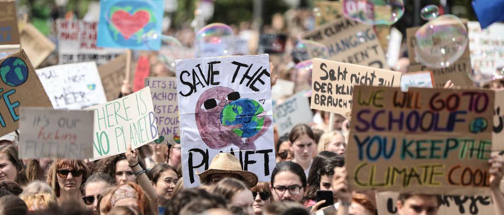 Schülerinnen und Schüler demonstrieren mit Protestplakaten während des Fridays for Future-Klimastreiks in Berlin. 