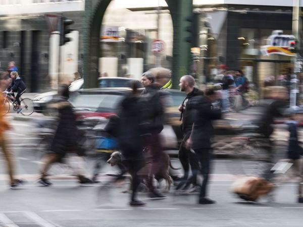 Fußgänger und Radfahrer überqueren die Wichertstraße an der Kreuzung Schönhauser Allee. Gastautor Mazda Adli wünscht sich mehr öffentliche Orte, die zum Verweilen einladen und Schutz vor Lärm bieten.
