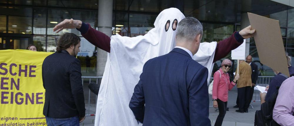 Ein Aktivist im Gespenster-Kostüm "erschreckt" einen Aktionär auf dem Weg zur Hauptversammlung der Deutsche Wohnen SE in Frankfurt am Main am 18. Juni 2019.