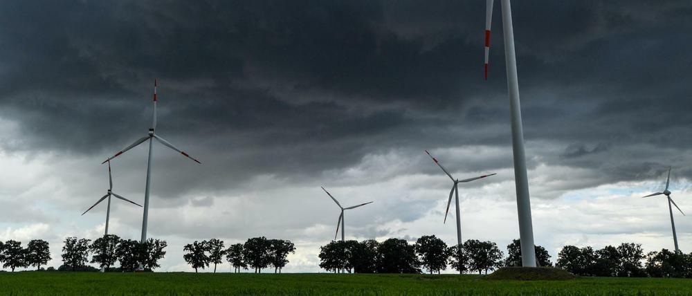 Dunkle Gewitterwolken ziehen über die Landschaft und Windenergieanlagen vom Windpark "Odervorland" im Landkreis Oder-Spree. (Archivbild)