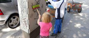 Mit ihren kleinen Besen haben die Kinder der 27 Helfer am Grazer Platz in Friedenau großen Spaß.