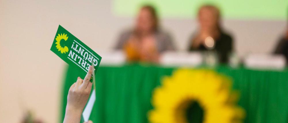 Beim Berliner Landesparteitag der Grünen hält eine Delegierte eine Stimmkarte mit der Aufschrift "Berlin Grünt!" in die Höhe. 
