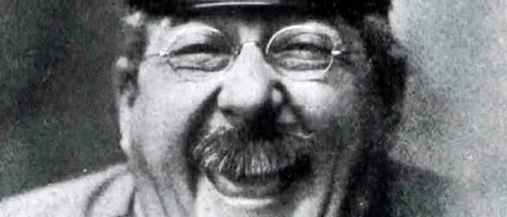 Das lachende Gesicht des Komödianten Henry Bender, der in der Rolle des Dienstmannes Max Pinne 1909 eine Schirmmütze trägt.