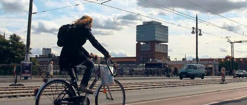 Eine Radfahrerin fährt über die Warschauer Brücke.