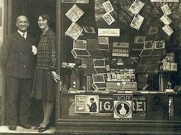 Das Foto zeigt das Ehepaar Krüger Ende 1929 am Eingang zu ihrem Tabakladen in der Eisenacher Str. 69 in Schöneberg.