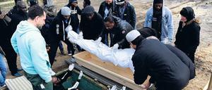 In Richtung Mekka. Ins Leichentuch gewickelt wird der Körper von Yusuf Aribidesi F. in das Grab hinuntergereicht.