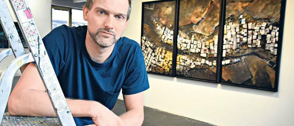 Hendrik Czakainski zeigt seine dreidimensionalen Wandbilder, die an Satellitenbilder erinnern.