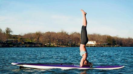 Sportlich. Auf einem Surfbrett kann man einiges tun – zum Beispiel Yoga machen. 