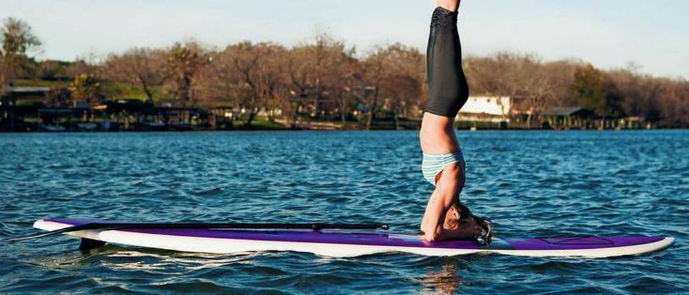 Sportlich. Auf einem Surfbrett kann man einiges tun – zum Beispiel Yoga machen. 