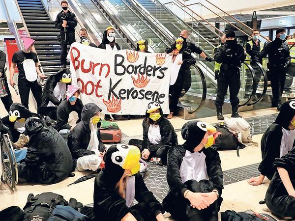 Protestierende Pinguine. Klimaschutzaktivisten demonstrieren gegen die BER-Eröffnung.