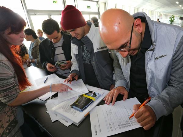 Ein Flüchtling aus Syrien füllt in der Hochschule Neu-Ulm (Bayern) ein Formular aus. Der 29-jährige besuchte eine Informationsveranstaltung der Hochschule. 