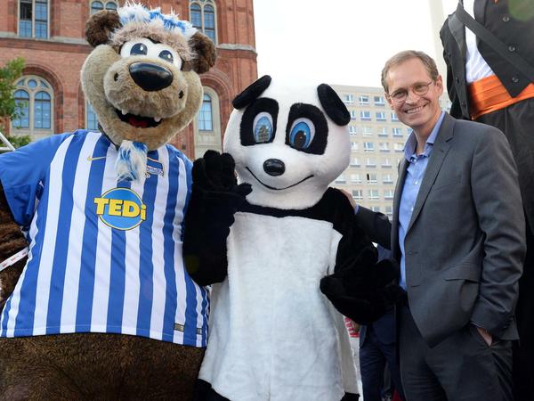 Michael Müller (r) mit dem Maskottchen von Hertha BSC (l) und dem neuen Pandabärmaskottchen des Berliner Zoos. 