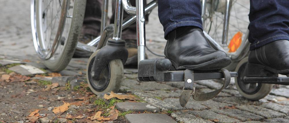 Alltag: Ein Rollstuhlfahrer bleibt mit seinem Rad im Kopfsteinpflaster hängen