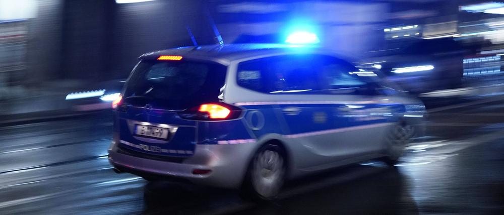 Ein Polizeiauto bei einer Einsatzfahrt mit Blaulicht (Symbolbild).