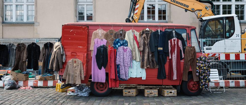 Street flea market with old used clothes Berlin, Germany - July 27, 2019: Street flea market with old second-hand clothes with hangers in a red van Copyright: xZoonar.com/jjfarquitectosx zoonar_14398712