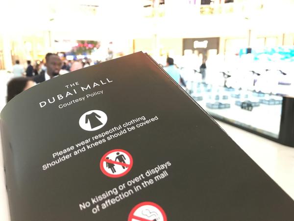 Kleiderordnung ("bitte Schultern bedecken") und Verhaltensregeln ("nicht küssen") in der Mall.